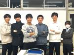 Student group standing in front of white board.